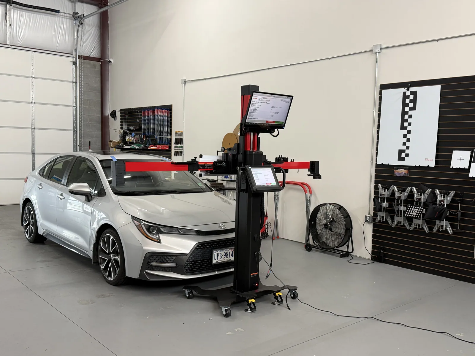 Toyota Corolla positioned in front of ADAS calibration targets with an Autel stand
