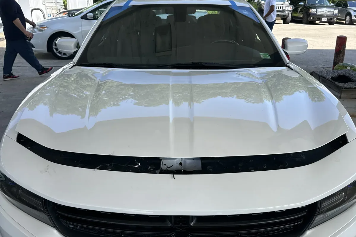 New windshield taped in place on a white Dodge Charger