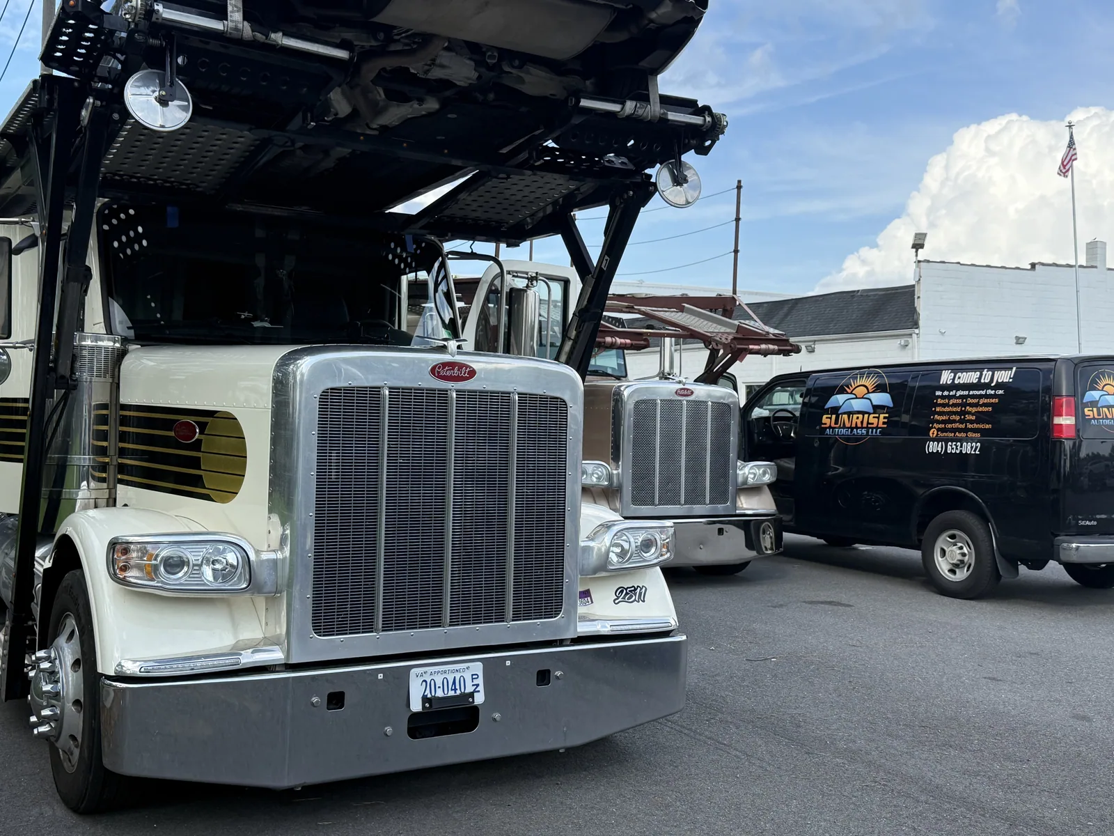 Peterbilt car haulers parked beside a Sunrise AutoGlass van
