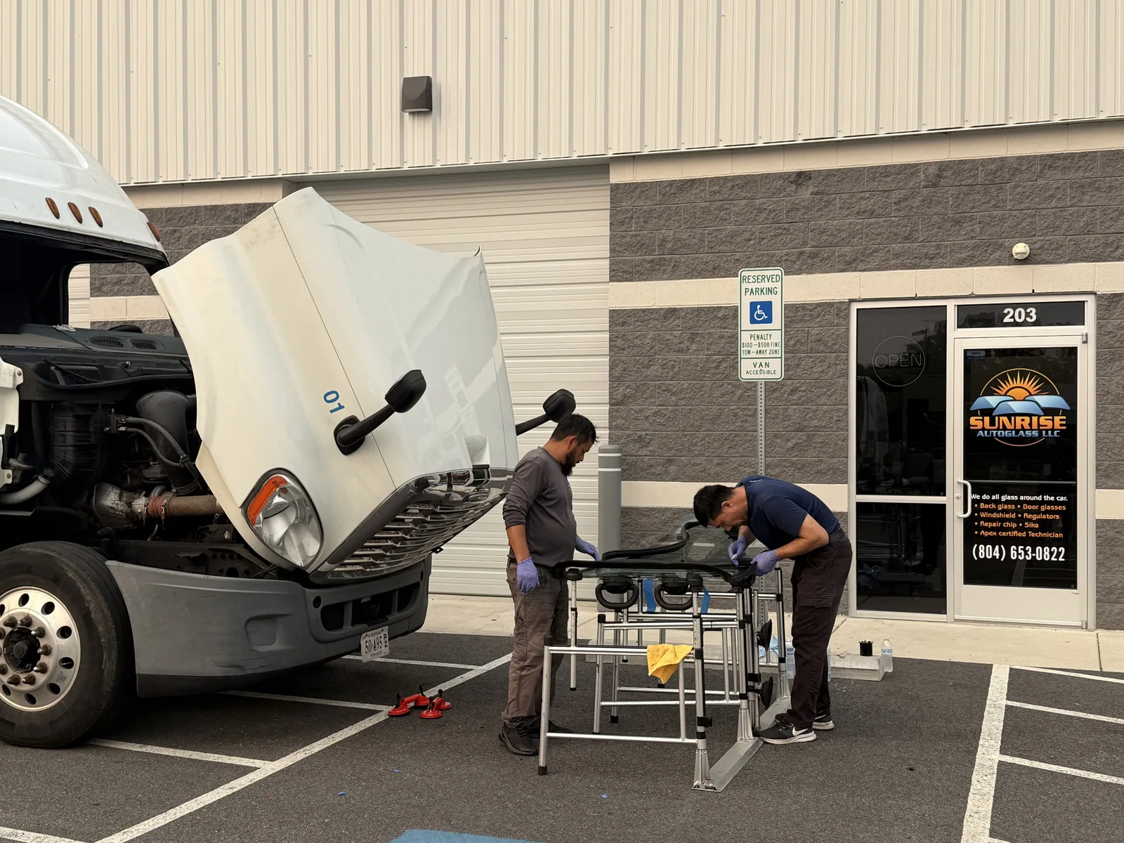 Sunrise AutoGlass technicians preparing a windshield outside the Mechanicsville shop
