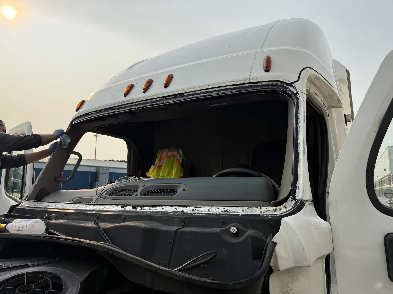 Technician setting new glass into a truck cab opening