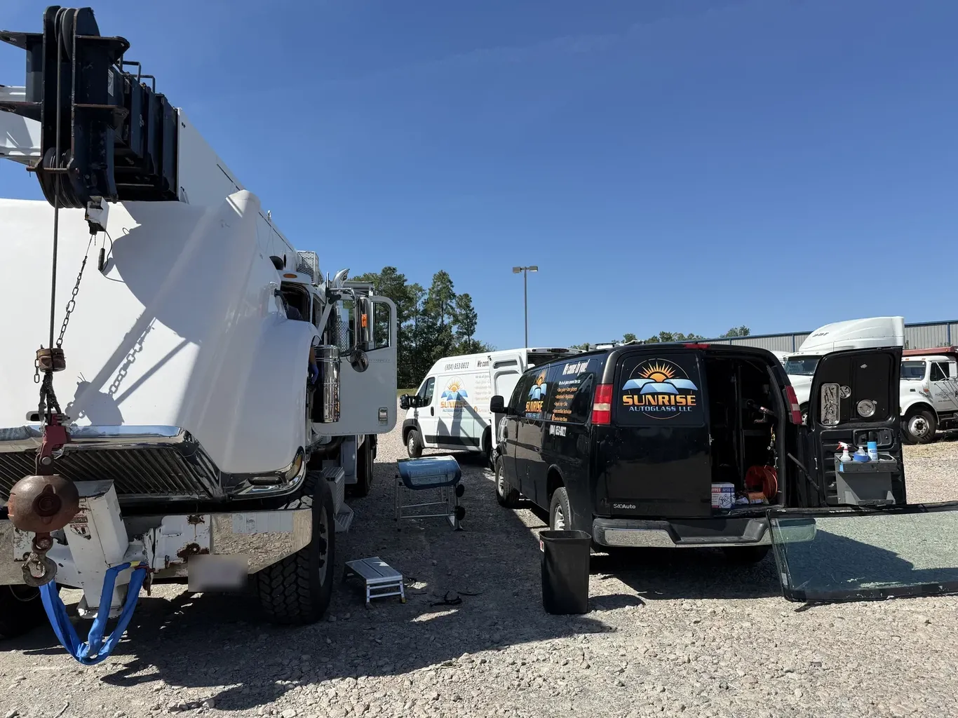 Sunrise AutoGlass vans working on site beside a truck